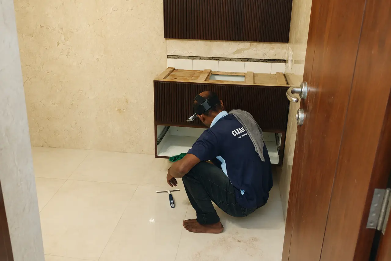 Operator in a head-mounted camera cleaning inside a base cabinet