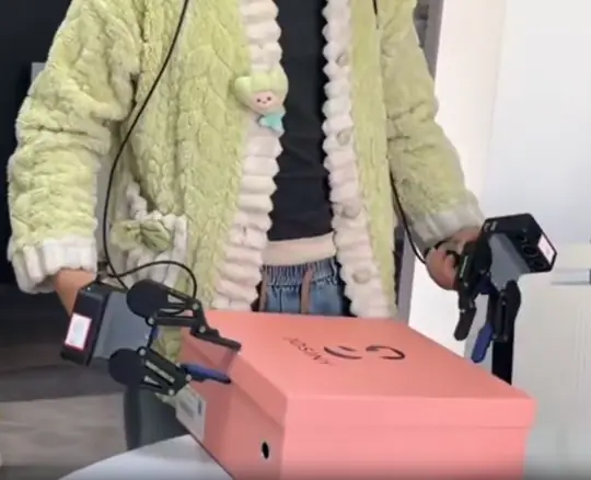 Operator using handheld tactile grippers to lift a box